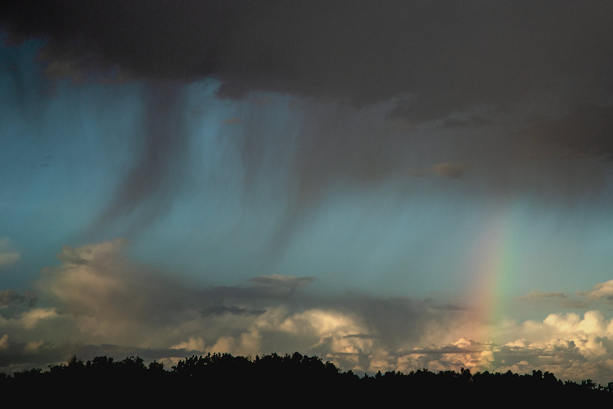 Stormy sky with rain and a rainbow